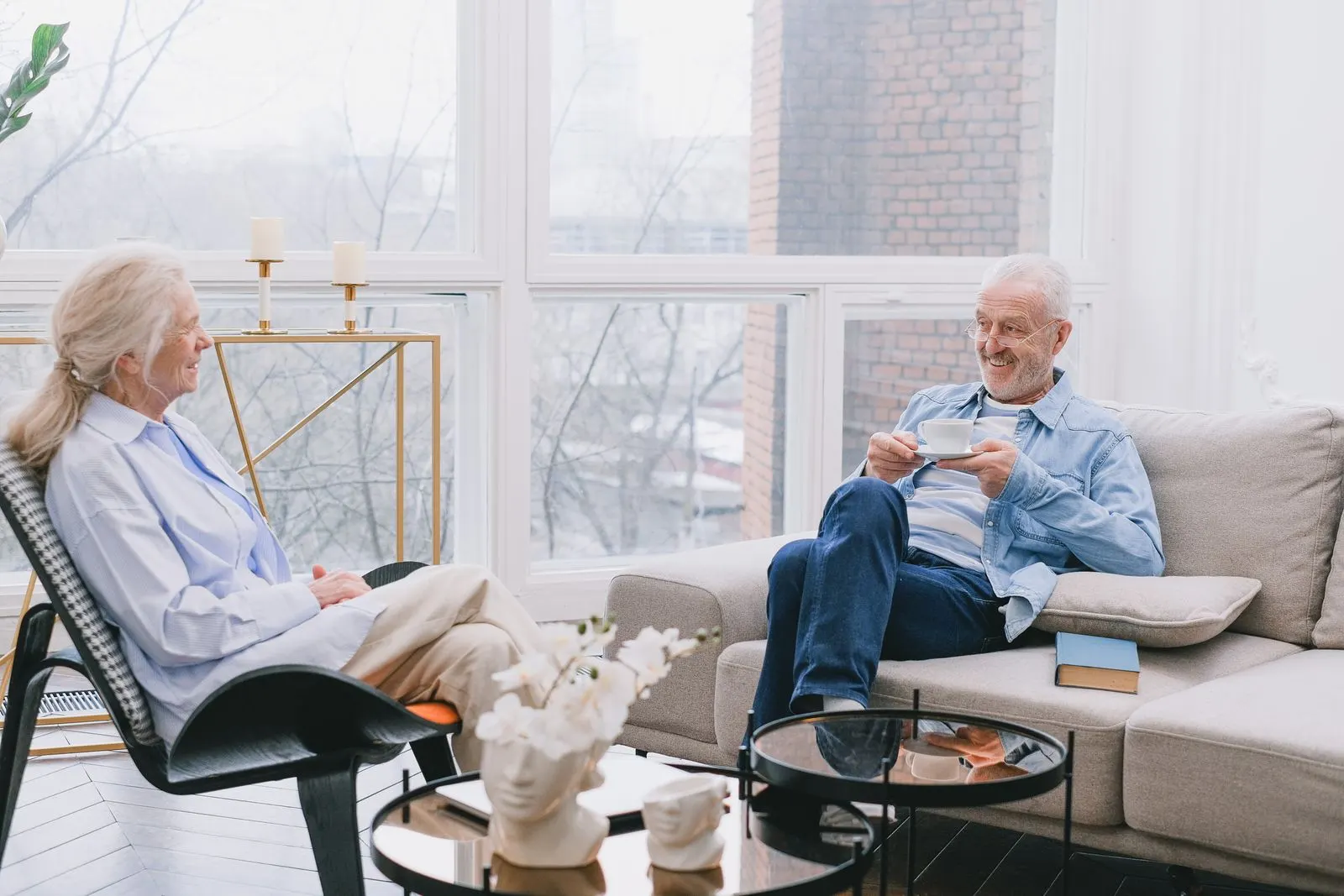 Two people talking over tea in a bright living room