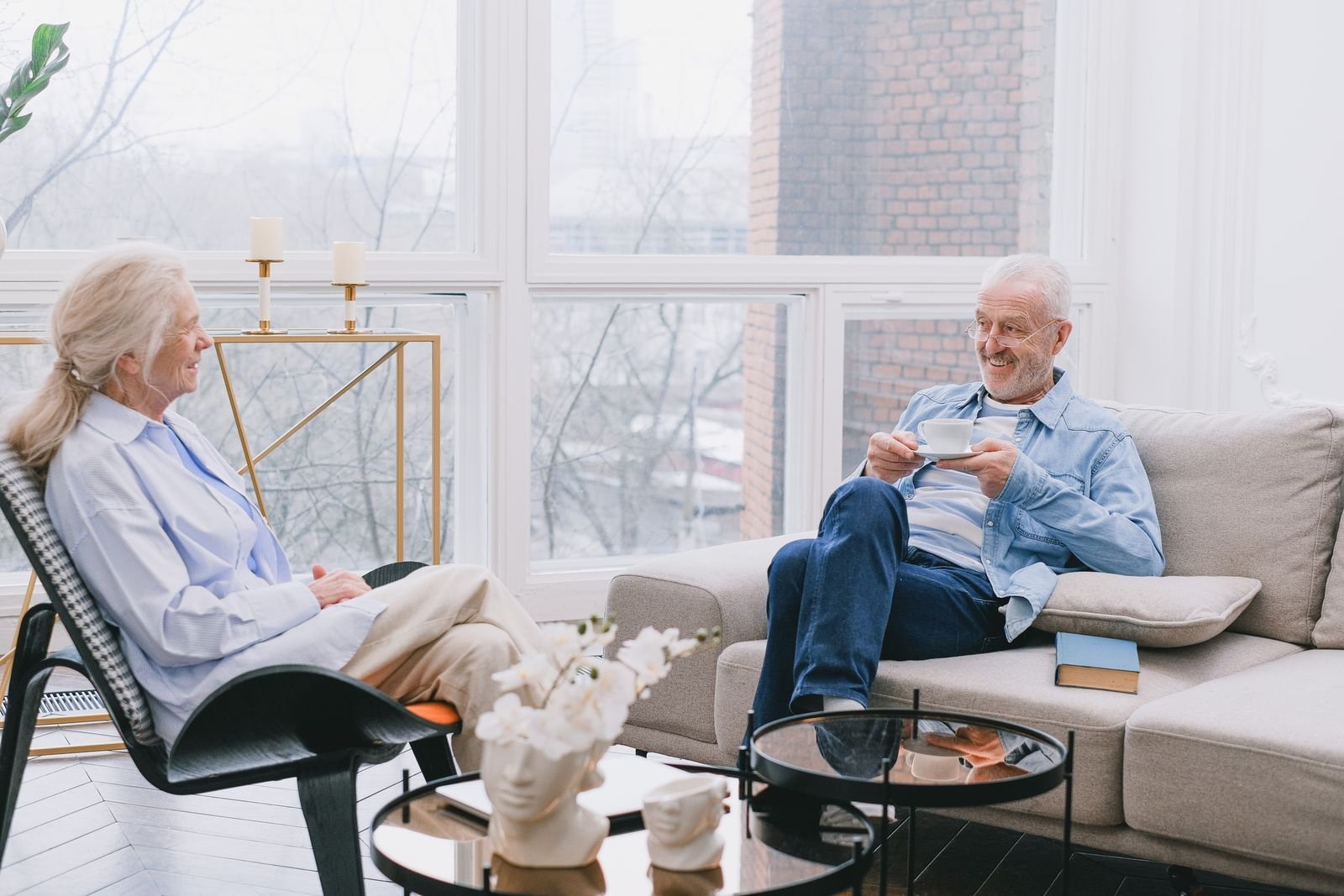 Stock photo: two people talking over tea in a bright living room, illustrating companionship support