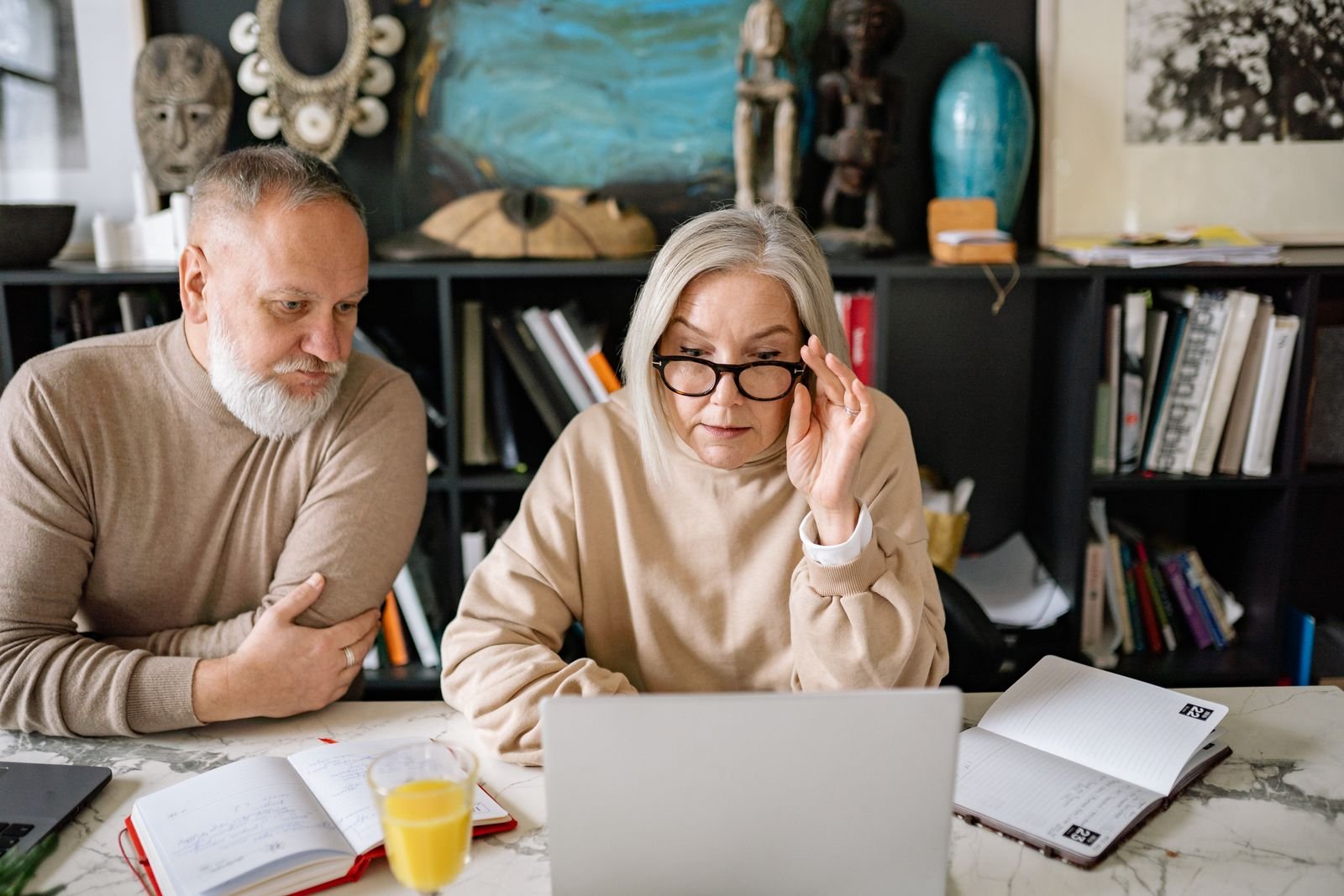 Stock photo: two people planning together with notebooks and a laptop, illustrating appointment support